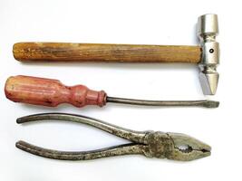 Vintage tools hammer, screwdriver, pliers. A classic still life showcasing aged craftsmanship. Perfect for DIY, repair, construction, or retro themes. Evokes feelings of nostalgia and hard work. photo