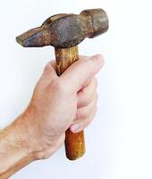 A weathered claw hammer, held firmly in a mans hand, symbolizes strength, craftsmanship, and hard work. The rustic texture and worn wood handle add character and authenticity. photo