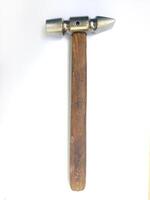 A meticulously detailed closeup showcases a vintage hammer with a worn wooden handle and a metallic head. The image evokes a sense of craftsmanship and timeless utility. photo