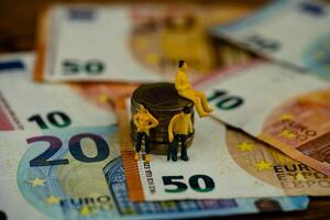 three figures with euro banknotes photo