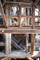 Bottom up view of old wooden beams in a medieval clock tower photo