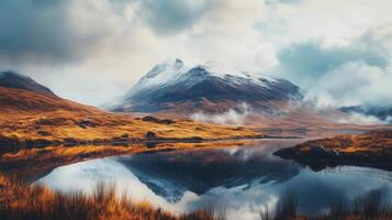 A mountain range with a lake in the foreground. The sky is cloudy and the mountains are covered in snow photo