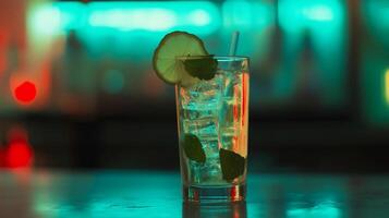 A glass of cocktail with a lime wedge on top. The drink is served on a table in a bar photo