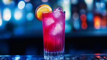 A glass of pink drink with an orange slice in it. The drink is served in a tall glass with ice cubes photo