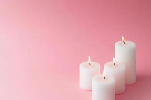 Elegant display of white candles glowing softly on a pastel pink background for serene ambiance and minimalist design inspiration photo