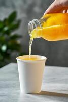 Refreshing lemonade is poured from a bottle photo