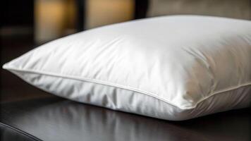 Gentle close-up of a pristine white pillow resting in a cozy bedroom environment photo