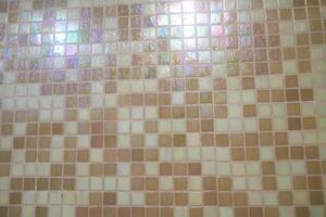 The texture of fine beige tiles. The small light tiles are positioned to fit into the background. Mosaic background of beige squares with space to copy photo