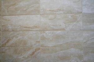 The texture of a thin beige tile. Small light waves are arranged so that they fit into the background. Beige tiles with space to copy photo