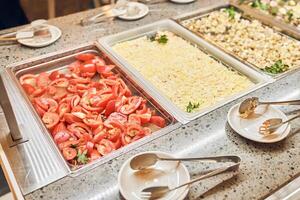 Selective focus on fresh sliced tomatoes and mimosa salad, traditional dishes in metal containers, and a buffet of Russian dishes. With space to copy photo