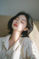 Asian woman sleeping on couch with her eyes closed photo