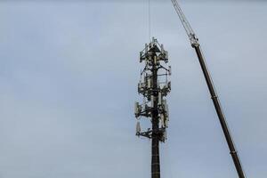 Worker Cliping Carabiner Harness for Safety on Antenna Tower installation of telecommunication tower photo