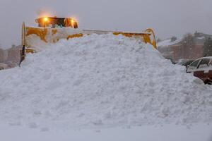 Winter. Wheel loader machine tractor removing snow. Clearing the road from ice and snow photo