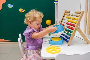 A little girl playing with an abacus photo