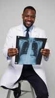 African American Doctor Holds XRay while Smiling Medical Portrait photo