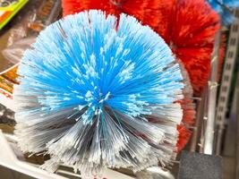 Close-up of blue and red cleaning brushes in store display photo