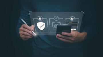 a man holding a smartphone and a tablet with a security icon on it photo