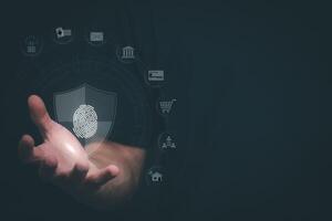 a person holding a fingerprint on a screen with icons of security and data security photo