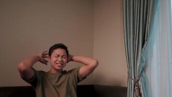 A man is feeling unwell. Data Computer is missing. A man bends down, holding his stomach. His face clearly shows discomfort and sickness. This scene takes place in a simple house. video