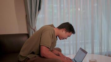 A man is working on a laptop carelessly. Data is lost. His posture and environment reflect a stressful workspace. video