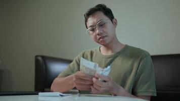 Counting the cost a contemplative man meticulously counts currency, his expression a blend of concern and determination, hinting at the weight of financial matters. video