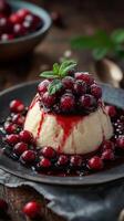 Delicious creamy dessert topped with fresh berries and berry sauce served on a dark plate photo