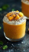 Delicious mango chia pudding topped with fresh mango cubes and whipped cream in a stylish glass bowl photo