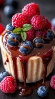 Decadent dessert topped with fresh raspberries and blueberries drizzled with chocolate sauce photo