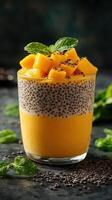 Delicious mango and chia seed dessert served in a glass with fresh mint leaves on top photo