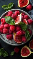 Bright and vibrant assortment of fresh raspberries and figs arranged in a bowl with mint leaves on a dark surface photo