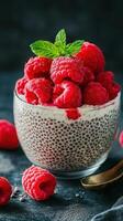 Delicious chia pudding topped with fresh raspberries and mint leaves in a stylish bowl photo