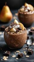Chocolate dessert topped with fresh pears and whipped cream served in a glass bowl with chocolate pieces photo