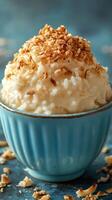 Creamy rice dessert topped with crunchy oats in a blue bowl, perfect for a sweet treat during any time of the day photo