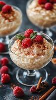 Creamy dessert served in glass bowls with raspberries and cinnamon on a dark countertop photo