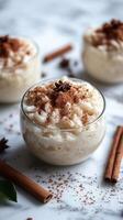 Creamy rice pudding topped with cinnamon and spices served in clear glass bowls photo