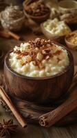 Creamy rice pudding bowl topped with cinnamon and nuts on a rustic wooden table in a cozy kitchen photo