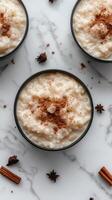 Creamy rice pudding topped with cinnamon and spices on a marble countertop photo