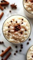 Creamy rice pudding topped with chocolate chips and cinnamon on a marble surface photo