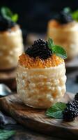 Delicious dessert featuring creamy rice pudding topped with black caviar and mint leaves served on a wooden platter photo