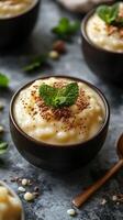 Creamy dessert served in a dark bowl garnished with mint leaves and chocolate crumbs photo