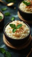 Creamy rice pudding topped with toasted coconut and mint leaves served in dark wooden bowls photo