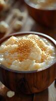 Creamy dessert served in wooden bowl with golden sprinkles and rich texture on rustic wooden table photo