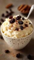 Creamy rice pudding topped with raisins and cinnamon in a decorative bowl photo