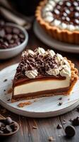 Delicious layered chocolate tart with whipped cream and chocolate shavings served on a wooden table photo