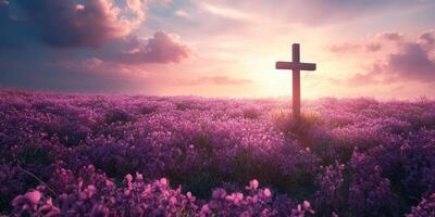 Vibrant purple flowers surround a wooden cross at sunset in a serene landscape photo
