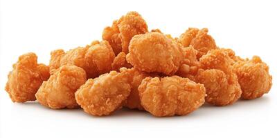 Crispy golden fried chicken bites piled high on a clean white surface perfect for snacking or sharing at any occasion photo