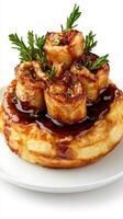 Delicious caramelized pastry topped with fresh herbs on a white plate photo