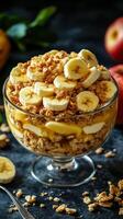 Delicious banana and granola parfait served in a glass bowl with fresh apple backdrop photo