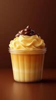 Creamy cupcake served in a clear container with layers of caramel and chocolate frosting, perfect for dessert lovers photo