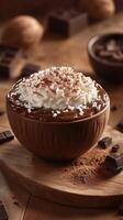 Delicious chocolate dessert topped with whipped cream and grated coconut served in a rustic bowl on wooden table photo
